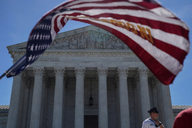 Un hombre sostiene una bandera fuera de la Corte Suprema de Estados Unidos en Washington, EEUU