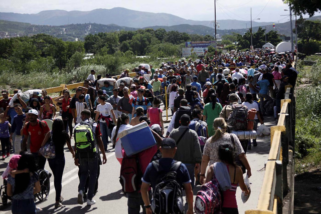 People cross the Colombian-Venezuelan border over the Simon Bolivar international bridge in San Antonio del Tachira
