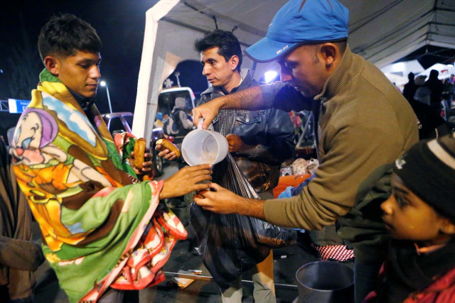 Colombians give food to Venezuelan migrants at the Rumichaca International Bridge, in Tulcan