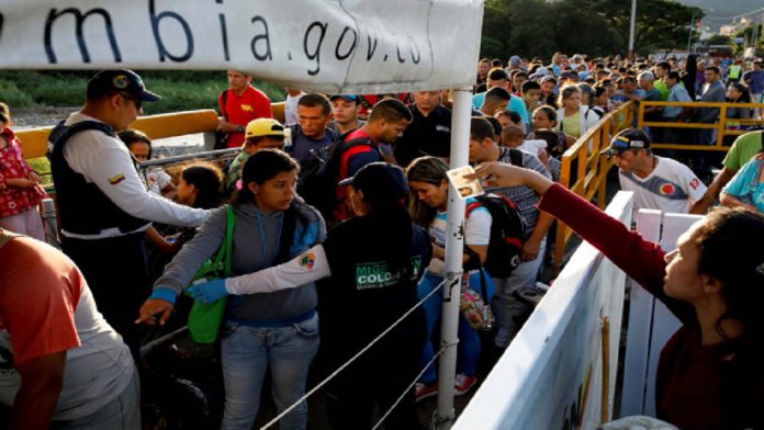 Foto de archivo. Funcionarios de migración de Colombia revisan los documentos de personas que tratan de entrar desde Venezuela, en el puente internacional Simón Bolívar en Villa del Rosario
