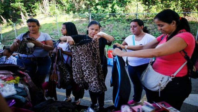 Fotografía del 3 de noviembre de 2019 de mujeres viendo ropa usada en un mercado de segunda mano en Caracas, Venezuela