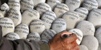 Un hombre escribe en un memorial a las víctimas en Perú. / C. B. (AFP)