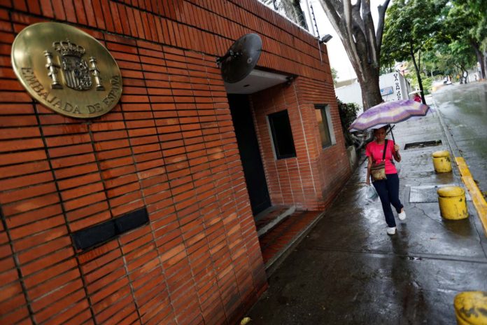 A pedestrian passes next to the Spanish embassy in Caracas